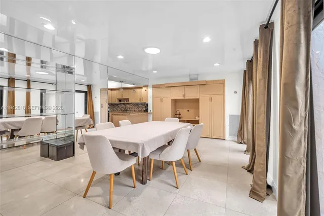 a dining area with stainless steel appliances kitchen island granite countertop a refrigerator and a sink