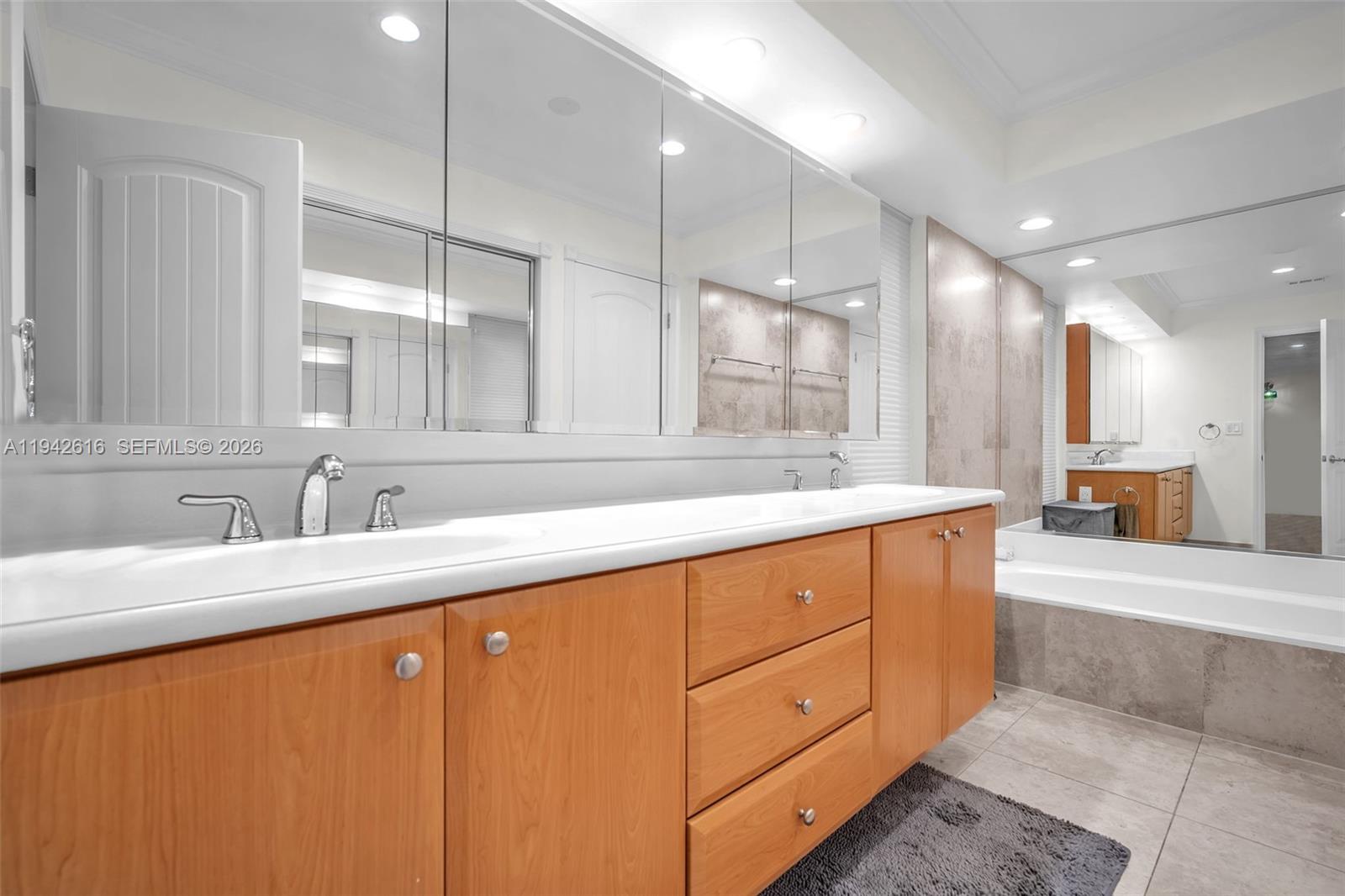 107 Heatherbrook Way, Unit 145 Hollywood, FL 33021 - Photo 25 of 57 a large kitchen with granite countertop a sink white cabinets and a large mirror