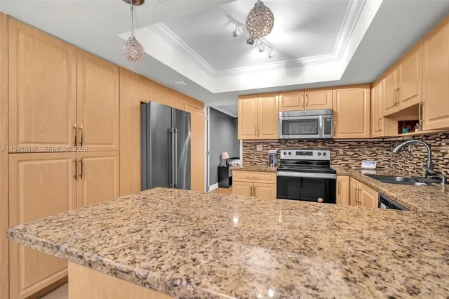 a kitchen with stainless steel appliances kitchen island granite countertop a stove sink and cabinets