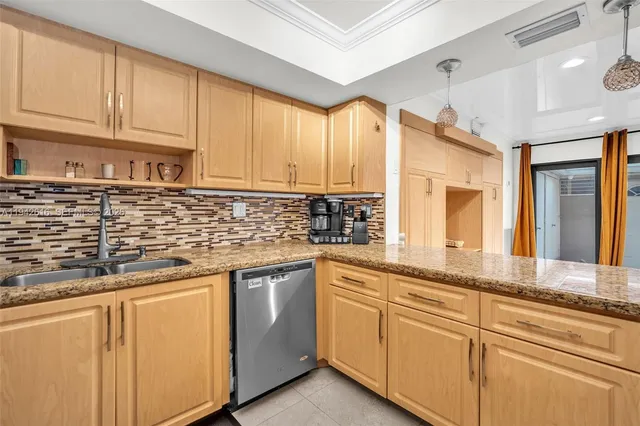 a kitchen with granite countertop a stove sink and cabinets
