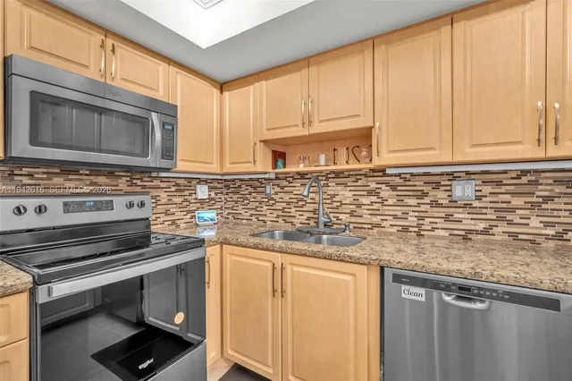 a kitchen with stainless steel appliances granite countertop a refrigerator stove and microwave