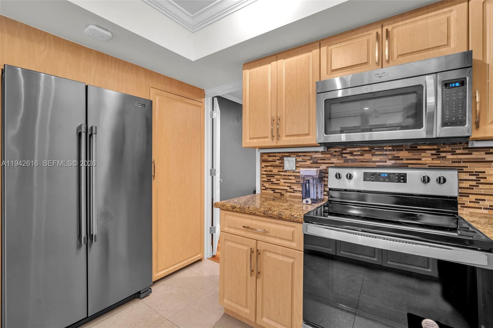 107 Heatherbrook Way, Unit 145 Hollywood, FL 33021 - Photo 9 of 57 a kitchen with stainless steel appliances granite countertop a refrigerator stove and microwave