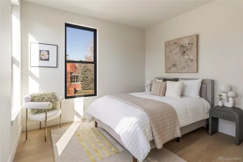 a bedroom with a bed and a painting on the wall