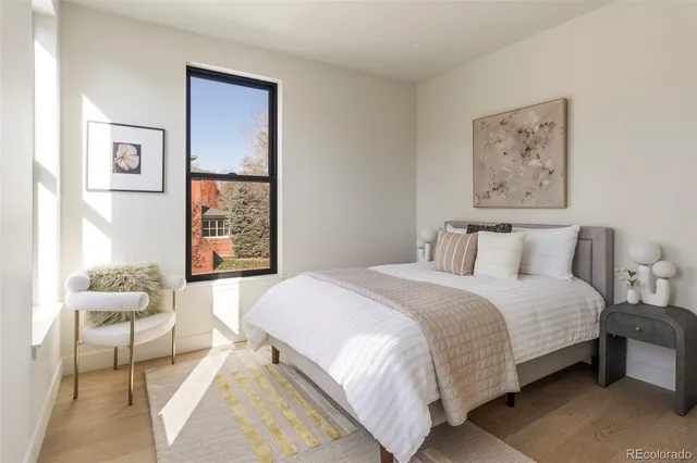 a bedroom with a bed and a painting on the wall