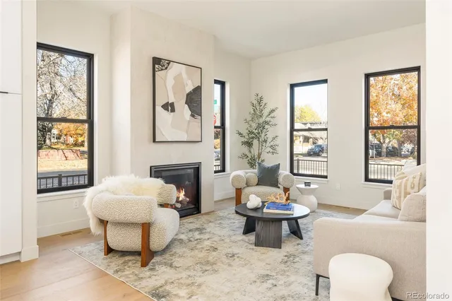 a living room with furniture a table and a large window