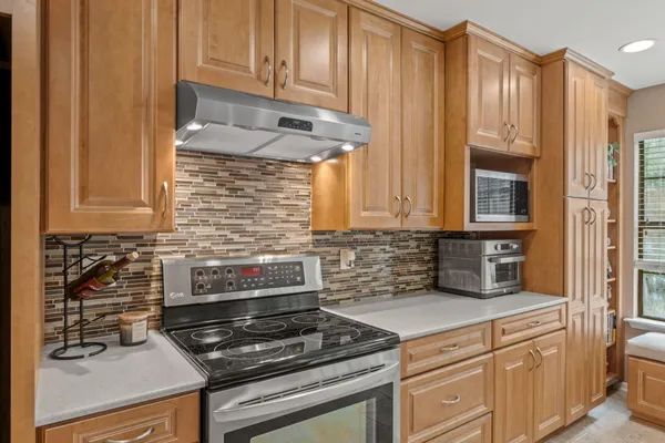 a kitchen with granite countertop a stove and cabinets