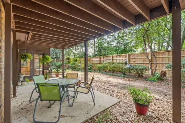 a view of a porch with chairs and potted plants