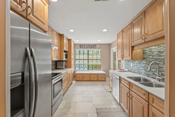 a kitchen with stainless steel appliances granite countertop a refrigerator a sink a stove and dishwasher