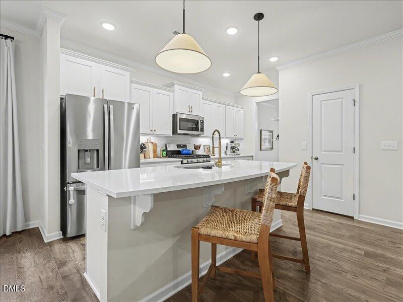 724 Summer Music Lane Raleigh, NC 27603 - Photo 10 of 70 a kitchen with stainless steel appliances a dining table chairs refrigerator and microwave