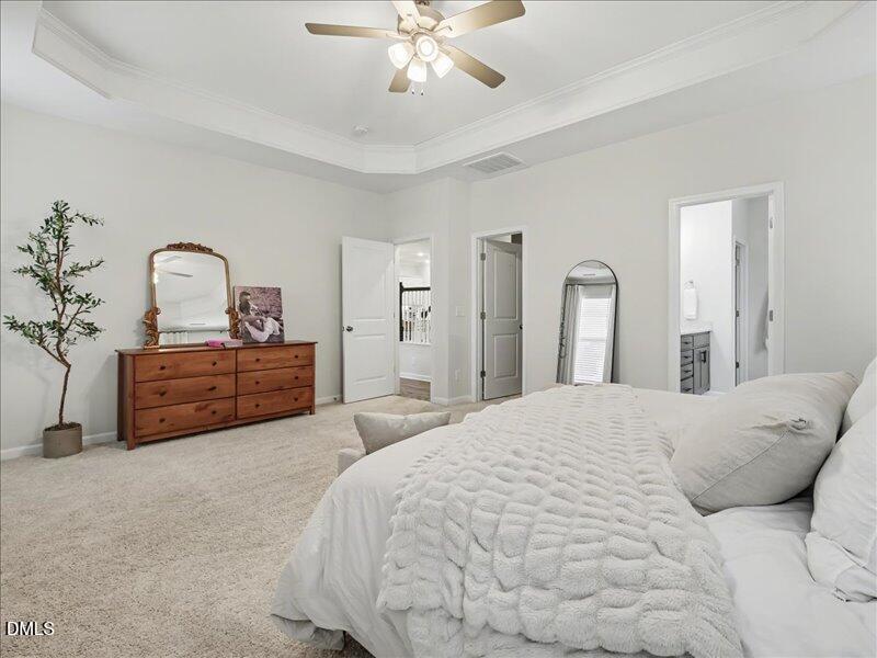 724 Summer Music Lane Raleigh, NC 27603 - Photo 28 of 70 a spacious bedroom with a bed and a chandelier