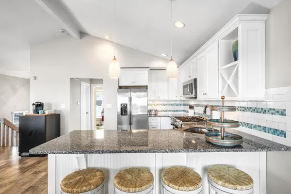 a kitchen with stainless steel appliances granite countertop a stove a sink and a refrigerator