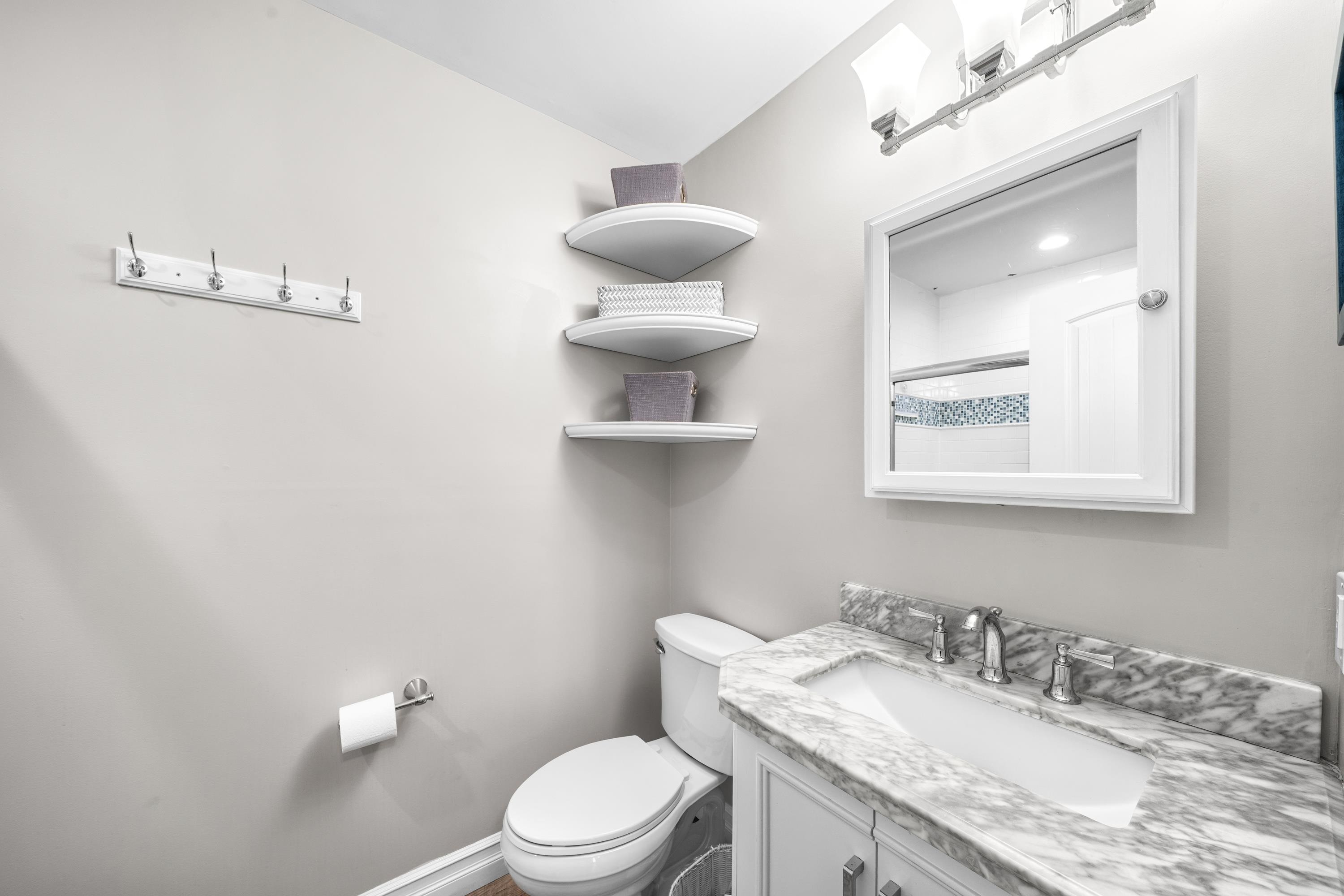 2934 Ocean Drive, Unit NORTH Avalon, NJ 08202 - Photo 21 of 33 a bathroom with a granite countertop toilet sink and mirror