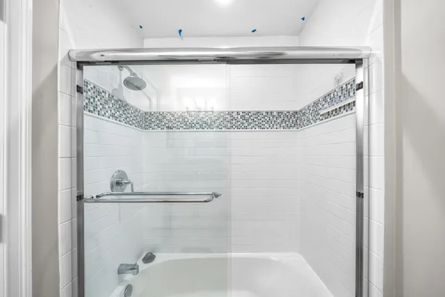 a bathroom with a shower and a glass door