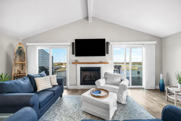 a living room with furniture kitchen view and a chandelier