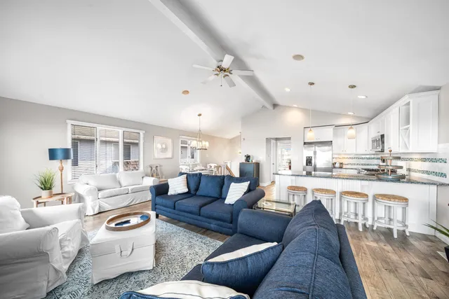 a living room with lots of furniture and kitchen view