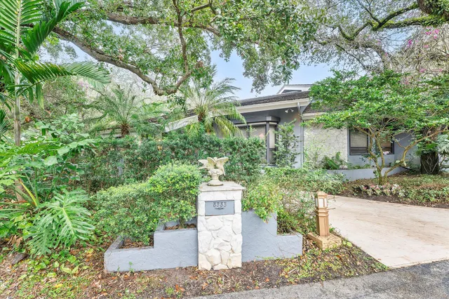 a view of a house with a yard and potted plants