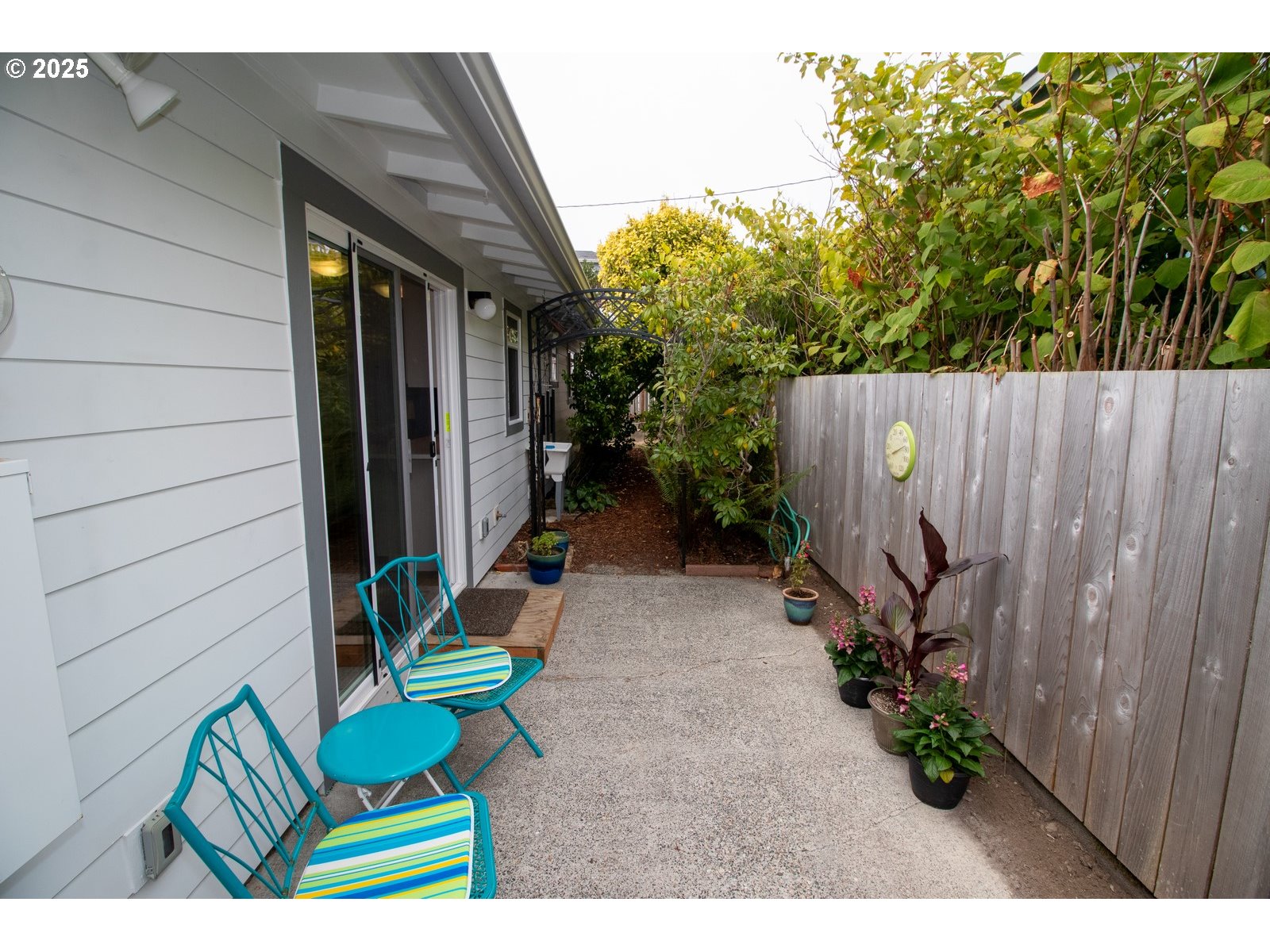 2 Eden Lane Florence, OR 97439 - Photo 43 of 48 a backyard of a house with chairs plants and wooden fence