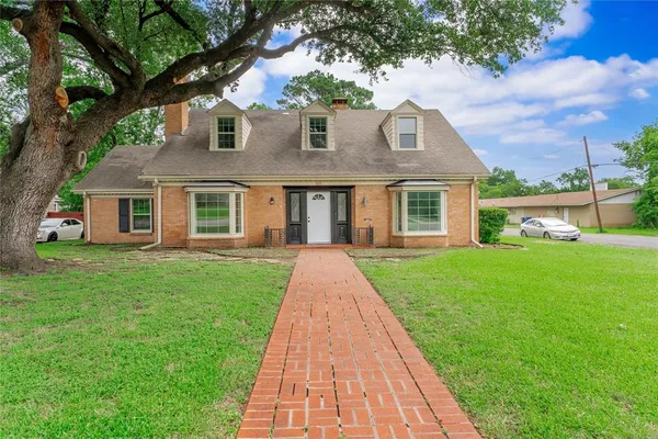 a front view of a house with a yard and trees