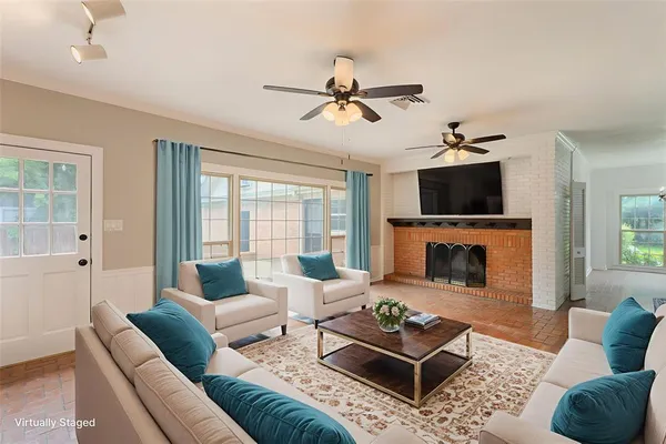 a living room with furniture a flat screen tv and a fireplace