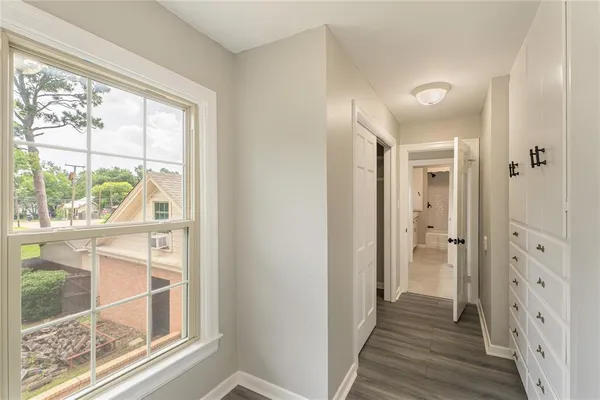a view of a hallway with wooden floor and windows