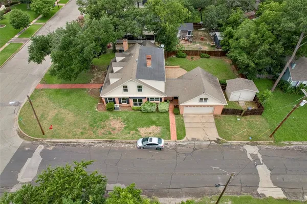 an aerial view of a house with a yard and lake view