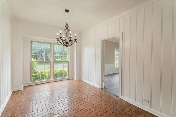 a view of a hallway with wooden floor and chandelier