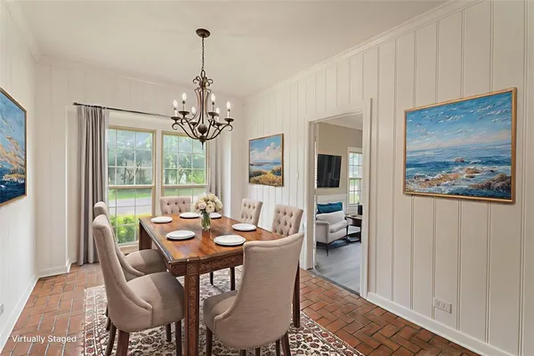 a dining room with furniture large windows and a chandelier