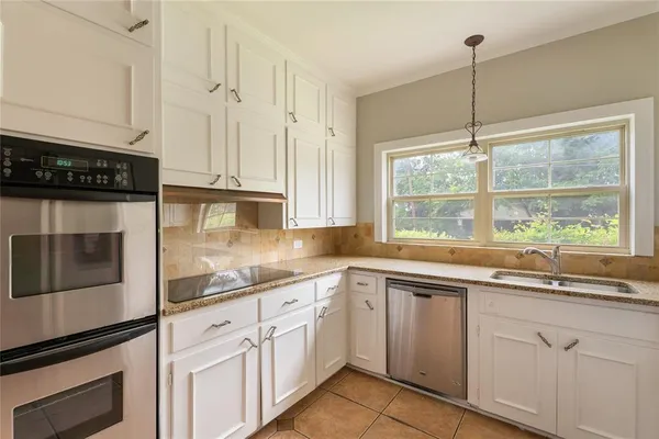 a kitchen with granite countertop white cabinets and white appliances