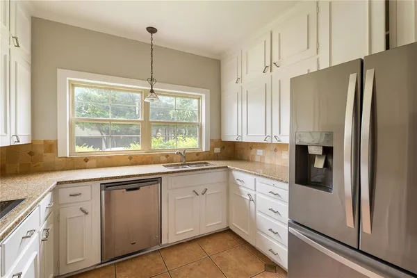 a kitchen with white cabinets and white appliances