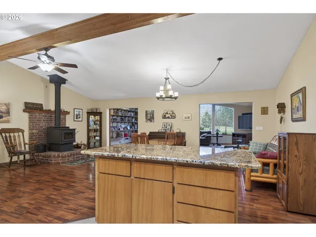 a kitchen with kitchen island granite countertop a sink cabinets and wooden floor