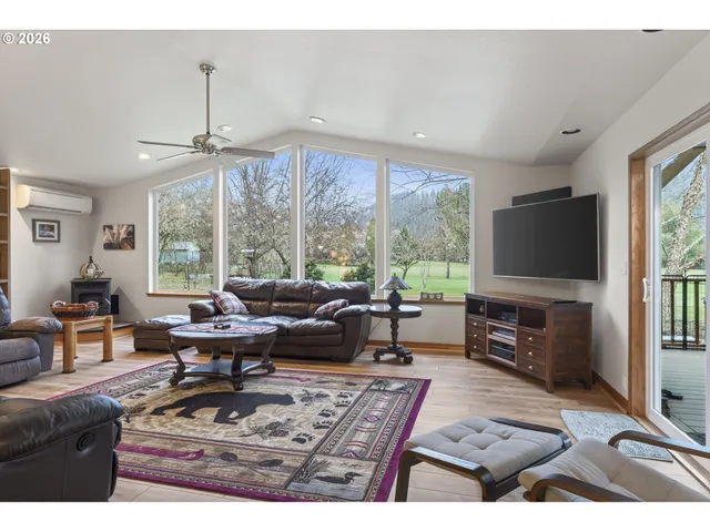a living room with furniture a flat screen tv and a large window