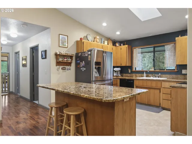 a kitchen with stainless steel appliances kitchen island granite countertop a sink and cabinets