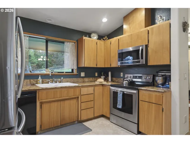 a kitchen with stainless steel appliances granite countertop a stove a sink and a microwave