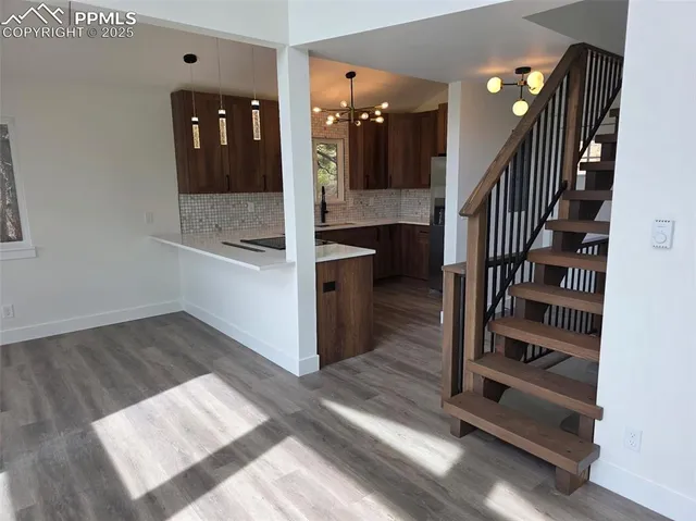 a view of a hallway with entryway and wooden floor