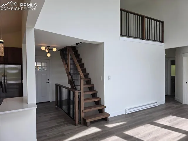 a view of a hallway with stairs and wooden floor