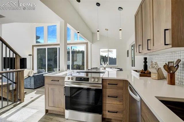 a view of a kitchen with kitchen island a stove a sink and a dining table view
