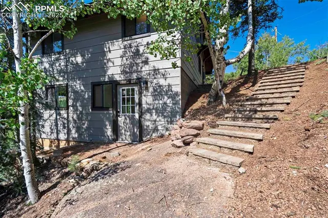 a view of a hallway with wooden floor and a bathroom