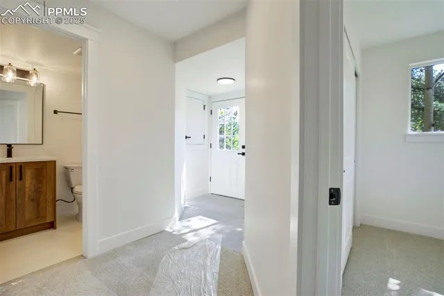 an empty room with windows and a fireplace