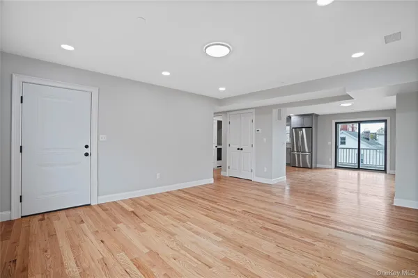 a view of an empty room with wooden floor and entryway