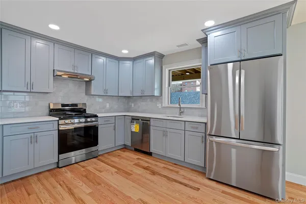 a kitchen with stainless steel appliances granite countertop a refrigerator stove and sink