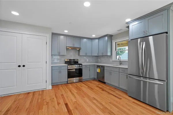 a kitchen with granite countertop stainless steel appliances a refrigerator sink and cabinets