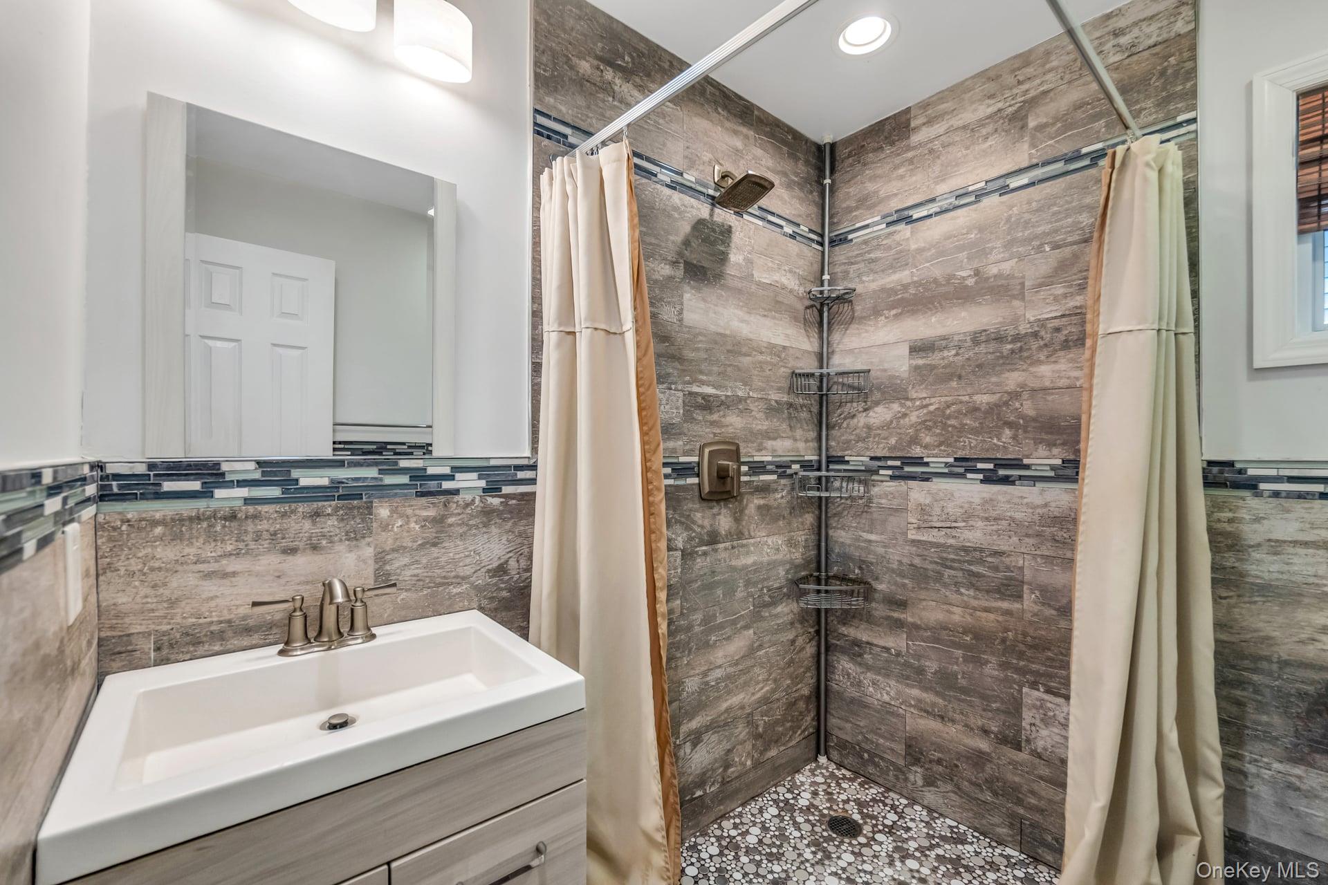30 Harding Road Ronkonkoma, NY 11779 - Photo 23 of 38 a bathroom with a shower and a sink a mirror