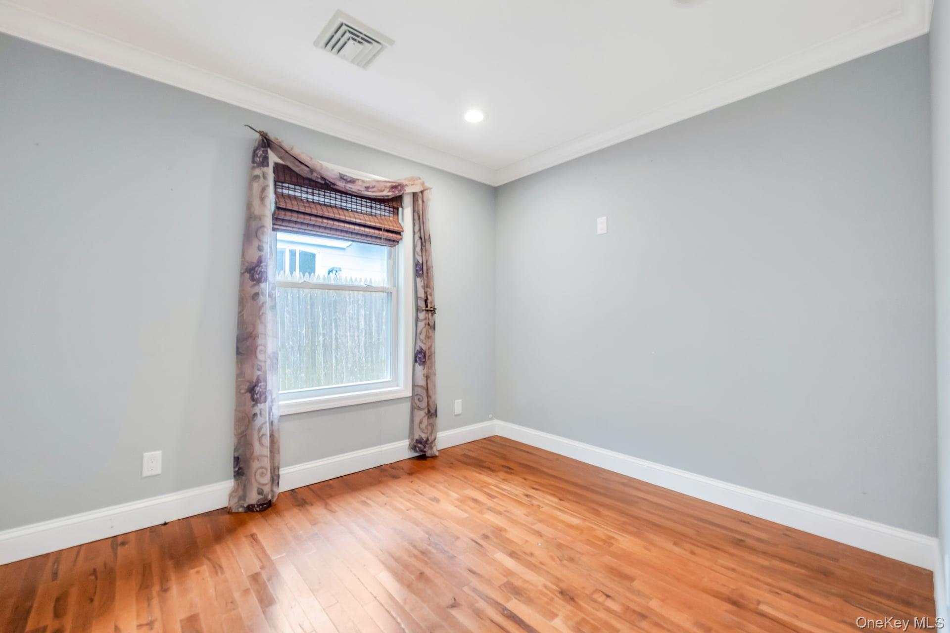 30 Harding Road Ronkonkoma, NY 11779 - Photo 28 of 38 an empty room with wooden floor and windows