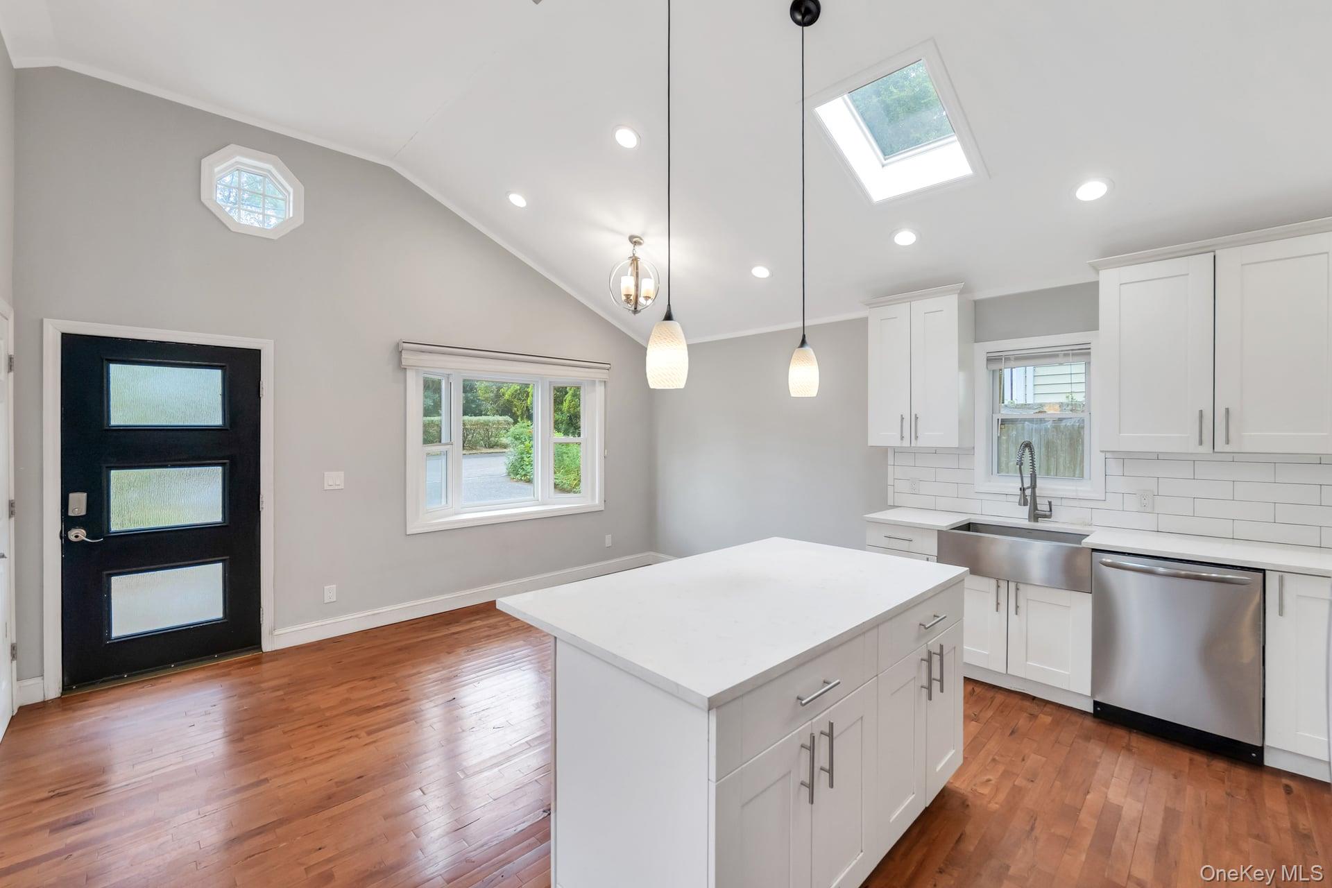 30 Harding Road Ronkonkoma, NY 11779 - Photo 6 of 38 a kitchen with a stove a sink a center island wooden floor and a window