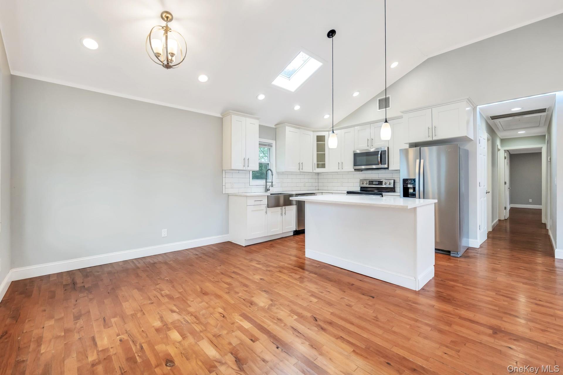 30 Harding Road Ronkonkoma, NY 11779 - Photo 8 of 38 a view of kitchen with kitchen island stainless steel appliances refrigerator stove and wooden floor