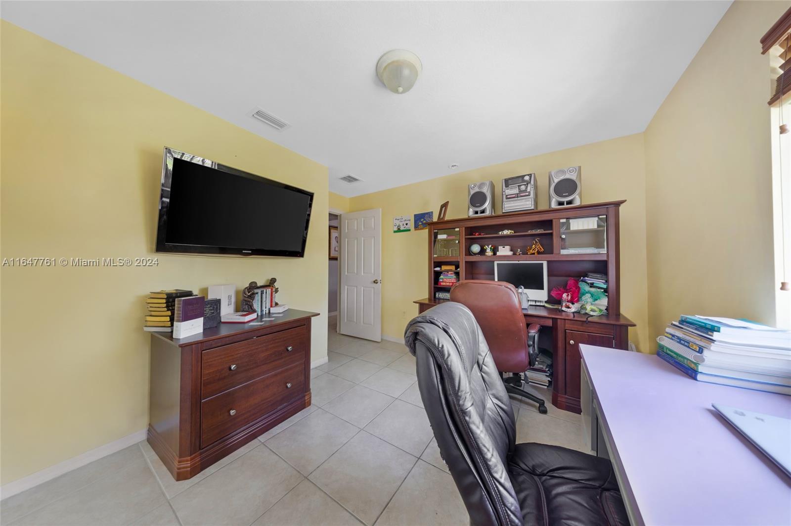 12431 Southwest 220th Street Miami, FL 33170 - Photo 11 of 34 a view of a workspace with furniture and a flat screen tv