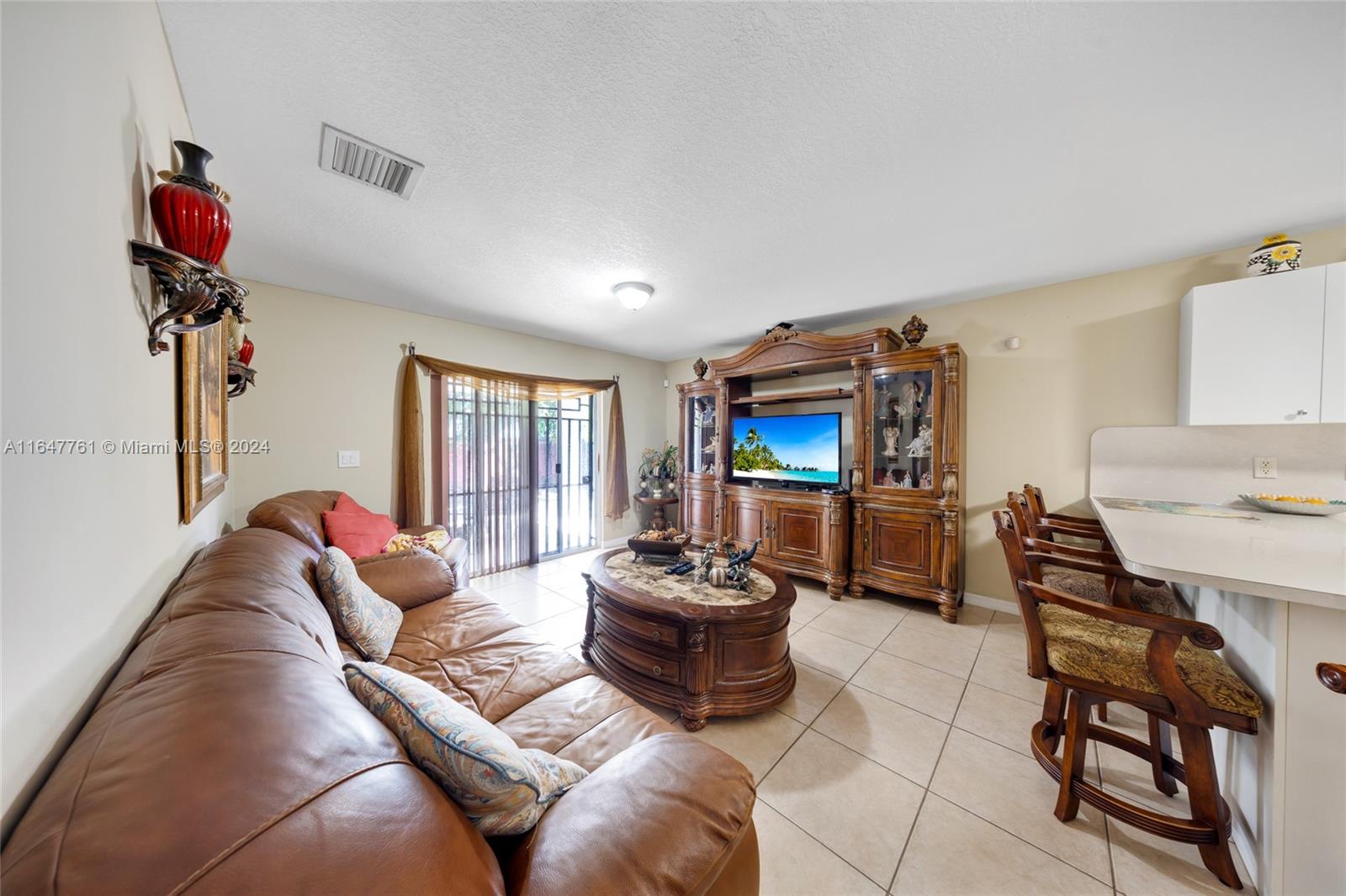 12431 Southwest 220th Street Miami, FL 33170 - Photo 20 of 34 a living room with furniture and a flat screen tv