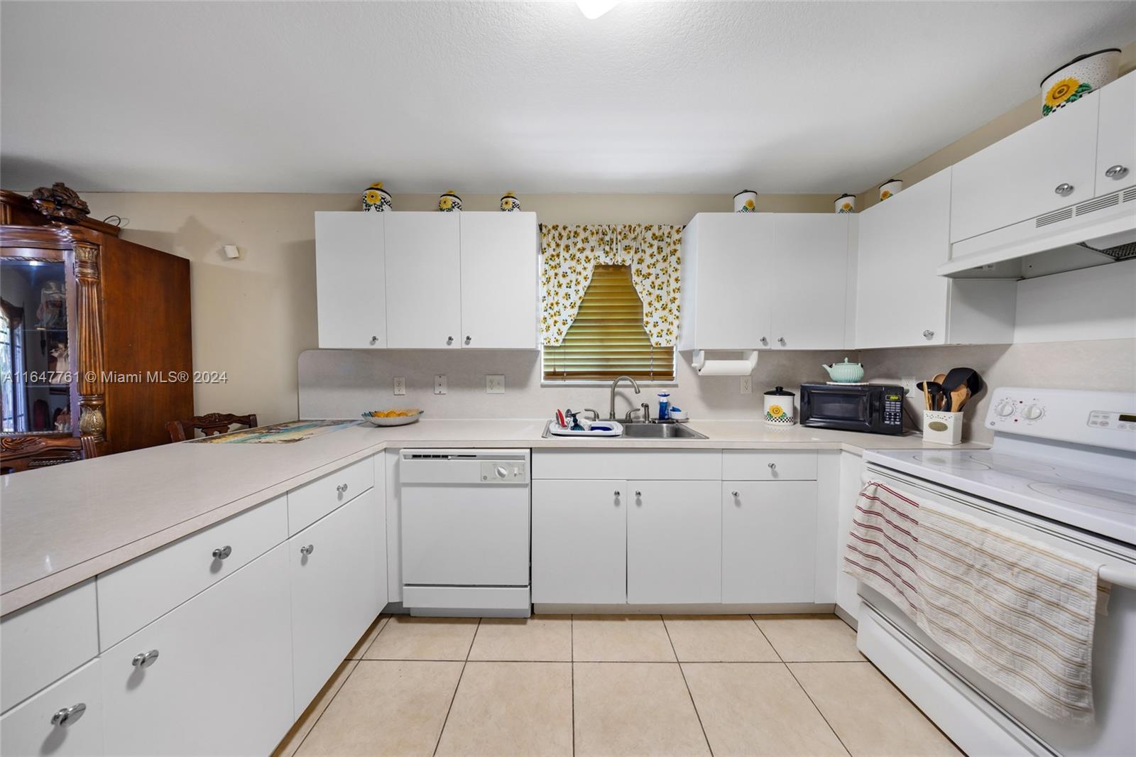 12431 Southwest 220th Street Miami, FL 33170 - Photo 22 of 34 a kitchen with a sink dishwasher and cabinets