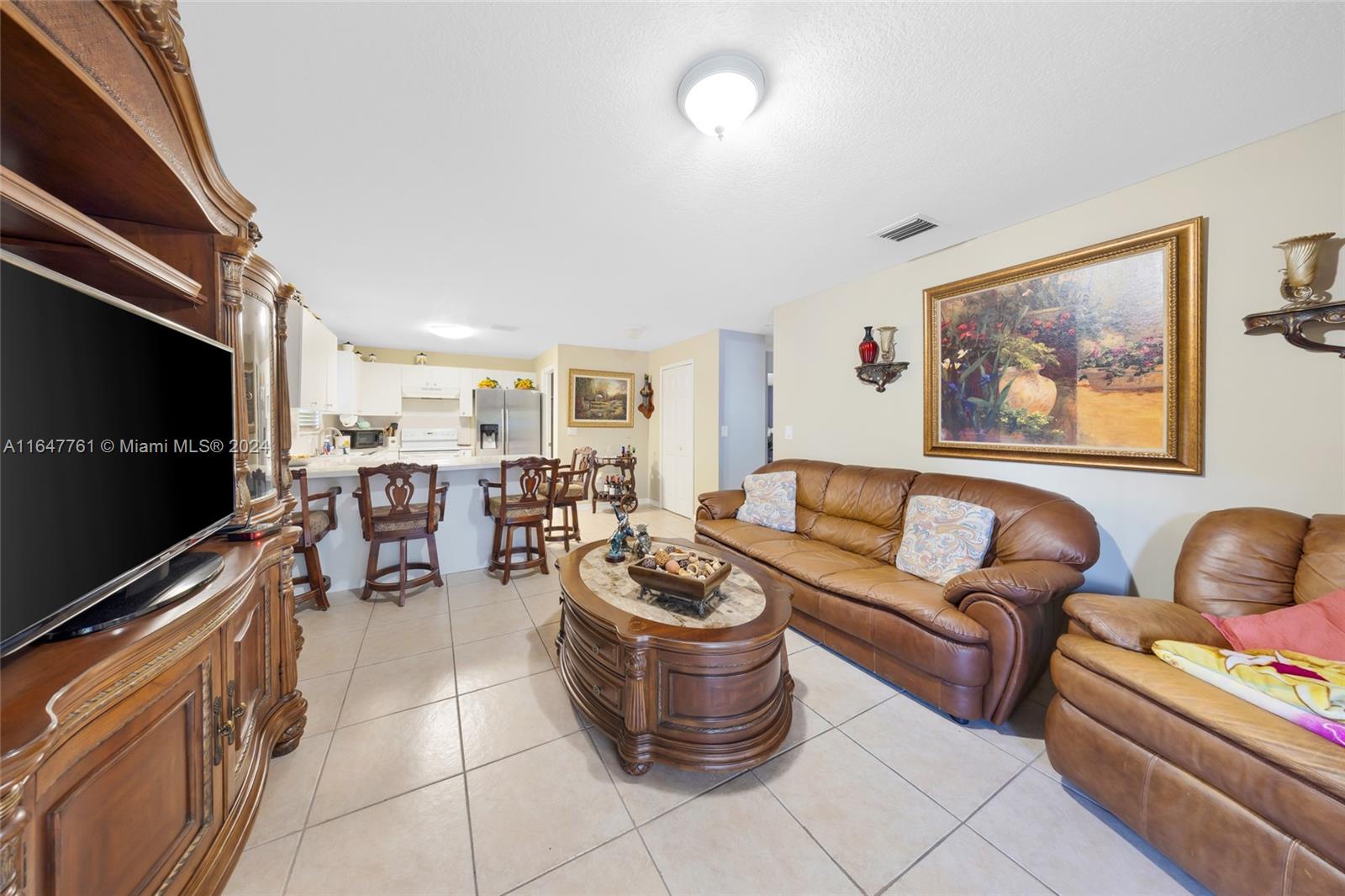 12431 Southwest 220th Street Miami, FL 33170 - Photo 24 of 34 a living room with furniture and a flat screen tv