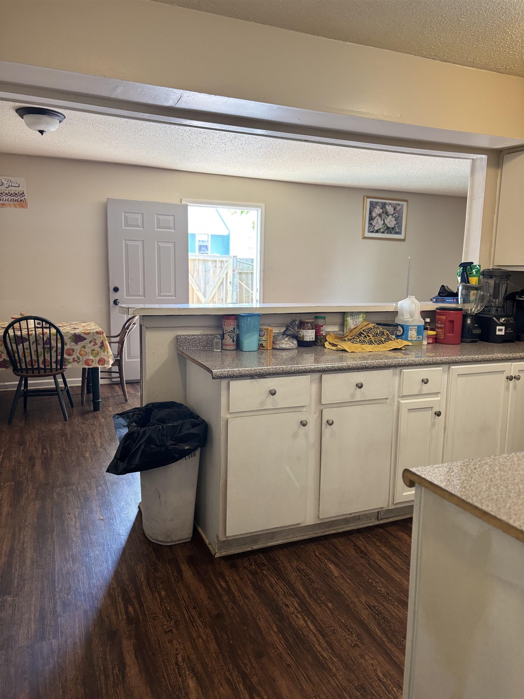 3626 Outland Road, Unit 86 Memphis, TN 38118 - Photo 6 of 24 Kitchen with dark wood-style floors, white cabinetry, a peninsula, light countertops, and a textured ceiling